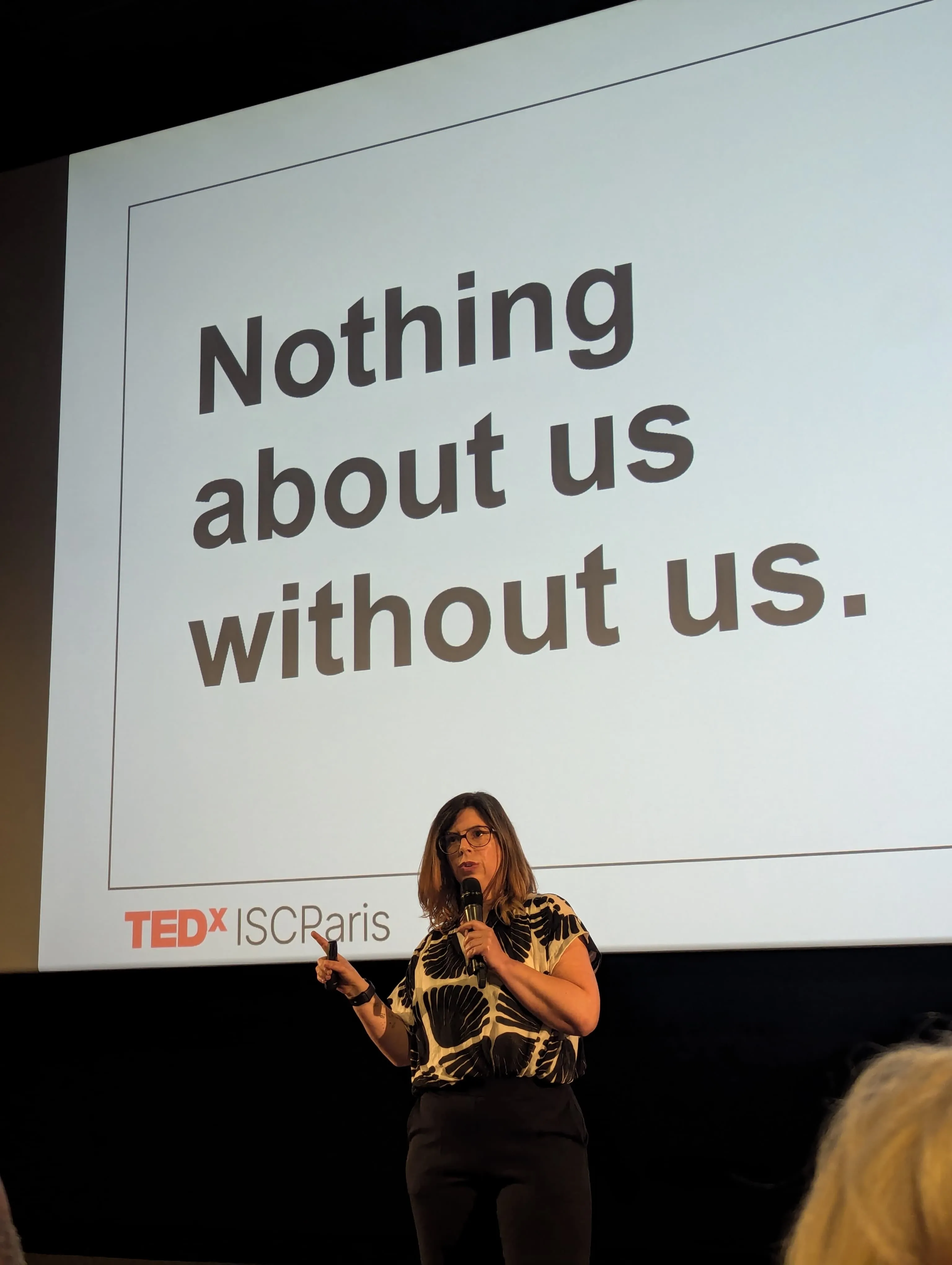 Emmanuelle ABOAF sur la scène du TEDxISC Paris, micro à la main